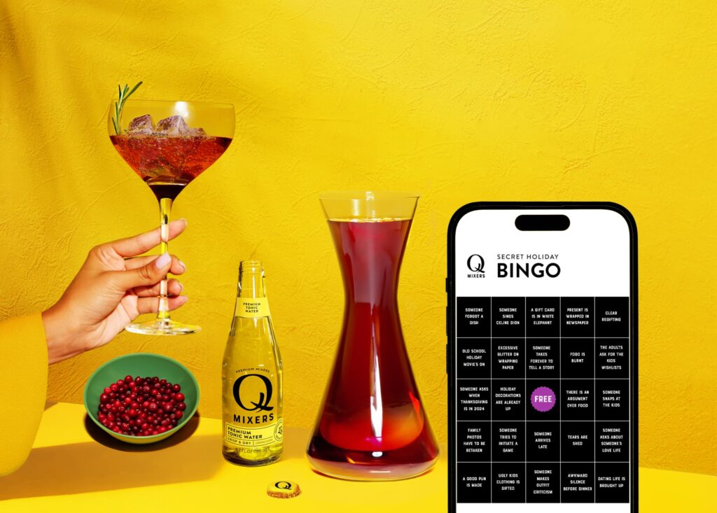 A table with all you need to make a perfect Q Mixers Cocktail, with a phone in front of it open on the Bingo game page